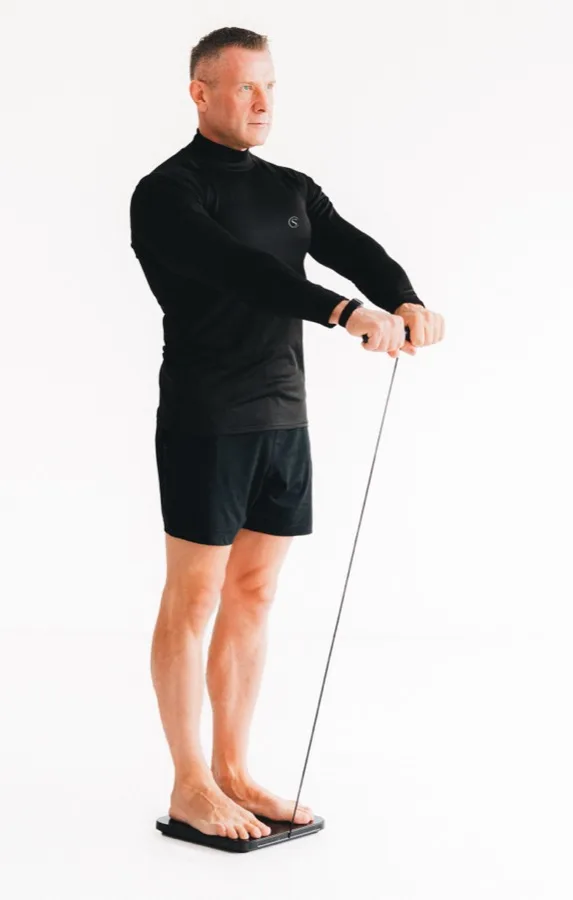 Tomas standing on the body composition pod, holding the handles, mid-measurement.